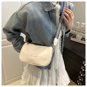 Chic cream crossbody bag with wide zebra-pattern strap and gold-tone metal buckles