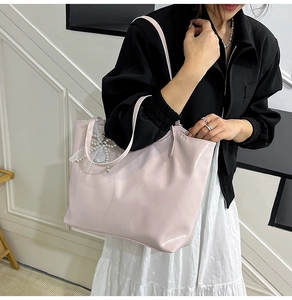 Detail of pink glossy patent leather tote bag with elegant lace pearl bow decoration