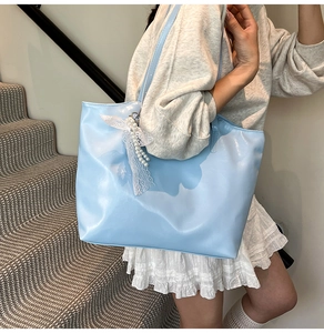 Light blue faux leather tote bag with elegant lace pearl bow accessory and glossy finish