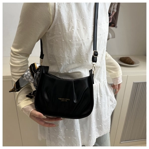 Détail du sac bandoulière noir plissé avec foulard décoratif et logo doré gravé