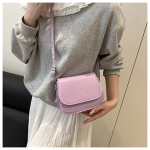 Light purple saddle bag detail on model with fashion trend silver lettering and leather strap
