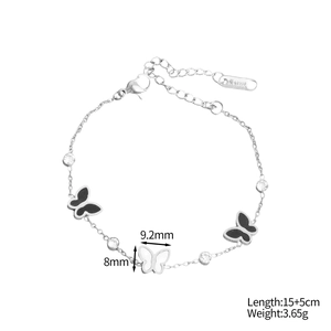 Détail des breloques papillon et gravure S.STEEL sur le bracelet plaqué or 18 carats