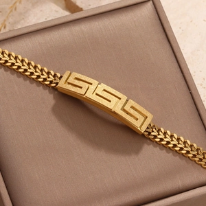 Close-up of gold Cuban chain bracelet with Greca pattern and matte sandblasted finish