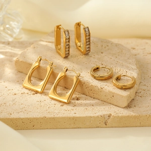 Three-piece gold earring set featuring geometric rectangular studs and textured hoops