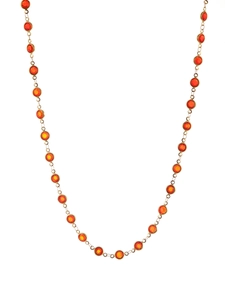 Detail of gold chain necklace with faceted orange-red bezel set crystals in a U-shape layout