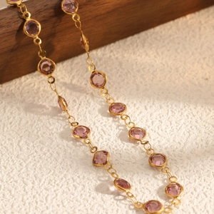 Elegant gold chain necklace featuring multiple bezel-set round pink purple gemstones