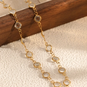 Elegant gold necklace featuring bezel-set round crystals on a delicate chain