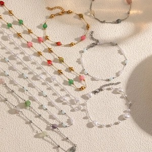Colliers de perles faits main avec breloques en cœur et pierres colorées sur texture