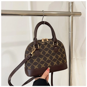 Close-up of vintage shell bag with brown geometric pattern and golden hardware details