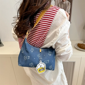 Blue denim crescent hobo bag with cartoon bear patterns and yellow leather shoulder strap