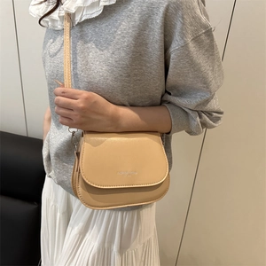Minimalist beige saddle crossbody bag with Fashion Trend logo shown on a model
