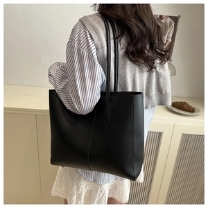 Gros plan d'un grand sac cabas en similicuir noir avec coutures verticales et bandoulières