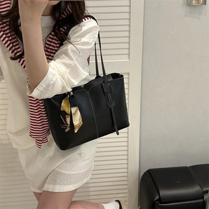 Retro black leather tote bag with white contrast stitching and decorative scarf on model