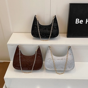Three snakeskin pattern baguette bags in black brown and white with gold chain straps