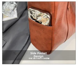 Detail view of the brown leather tote bag side pocket with a phone for storage display