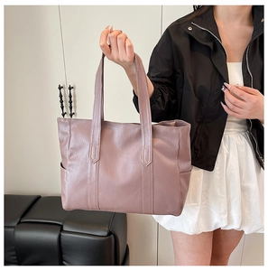 Detailed side view of the spacious dusty pink faux leather tote bag with side pocket