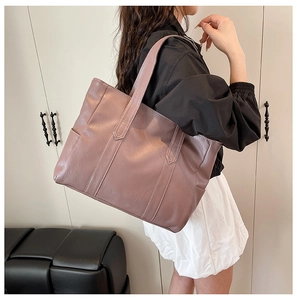 Dettaglio della borsa tote viola con trama a grana fine e cuciture verticali eleganti