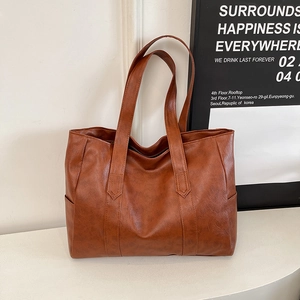Λεπτομέρεια της καραμελέ τσάντας tote με vintage υφή και ευρύχωρες πλευρικές τσέπες