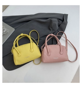 Close-up of mini leather handbags in yellow and pink showing premium lychee grain texture