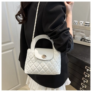 Detail of white quilted crossbody bag with golden chain strap and round metal twist lock
