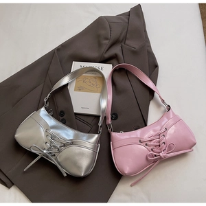 Detail of trendy silver and pink shoulder bags featuring corset-style lace-up design