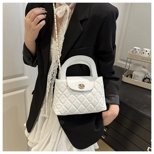 Detail of white quilted crossbody bag with gold-tone swivel lock and metal chain strap