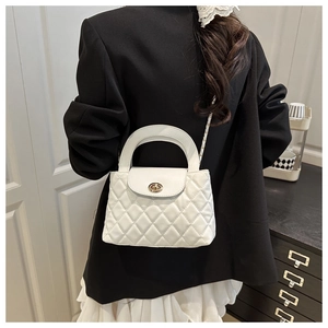 Quilted white chain crossbody bag with metal twist lock shown on model waist