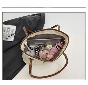 Top view of large cream tote bag interior showing capacity for laptop and daily essentials