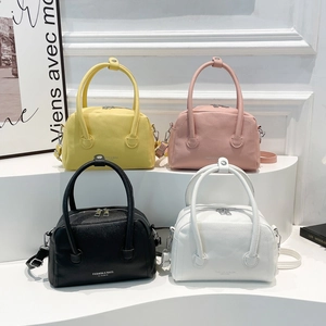 Fashionable lychee texture boston bags in four colors on a tiered display stand