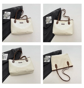 Detail view of cream tote bag with houndstooth texture and brown leather trim accents