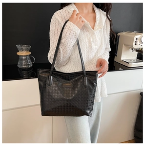 Detail of black houndstooth tote bag on model's shoulder with chic commute style