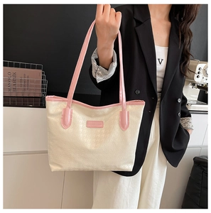 Close-up of houndstooth tote bag featuring pink patent leather trim and handles