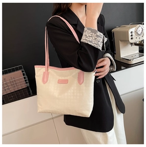 Detail of houndstooth jacquard fabric and pink leather strap on a large tote bag