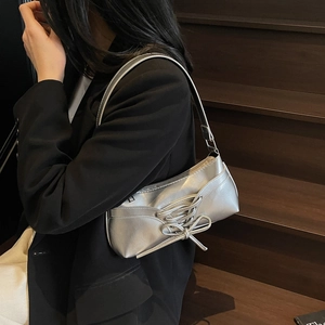 Silver metallic underarm bag with bow tie design and glossy PU leather finish