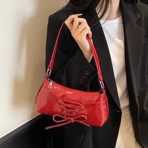 Red patent leather underarm bag with bow tie detail and zipper for summer 2025
