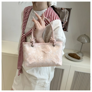 Close-up of pink tote bag with delicate lace mesh and 3D butterfly embroidery detail