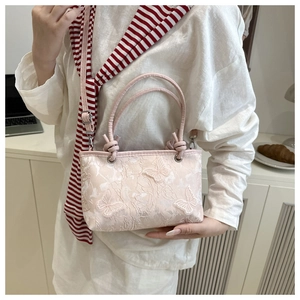 Ricamo dettagliato di farfalle sul pizzo rosa di una borsa a mano alla moda