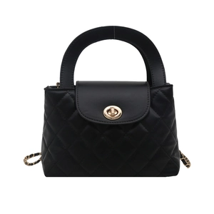 Black quilted crossbody bag with gold turn-lock and elegant metal chain handle