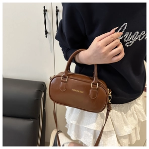 Détail du sac en cuir marron brillant avec inscription dorée FASHION & BAGS