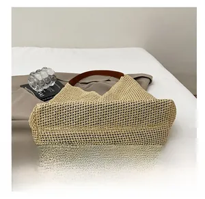 Detailed close-up of the durable hand-woven texture and bottom of straw shoulder bag
