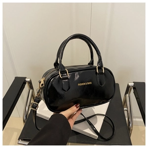 Sac Boston noir brillant avec lettrage doré et bandoulière réglable amovible