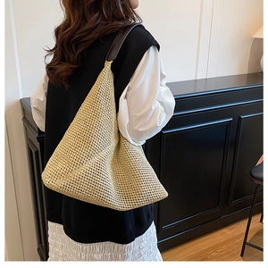 Handwoven straw shoulder bag in natural yellow featuring a large hobo style and brown strap