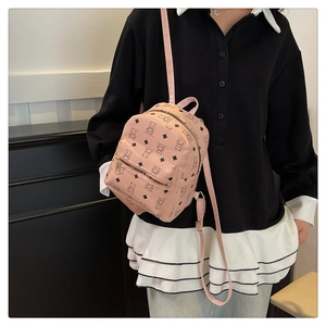 Nahaufnahme eines rosa Minirucksacks mit Bärenmuster und Rautenmotiv an der Schulter