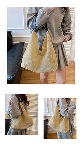 Detail of hand-woven beige straw tote bag with black leather shoulder straps