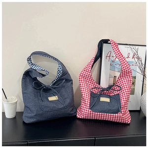Detail of denim and plaid tote bags featuring bow decoration and a leather fashion label