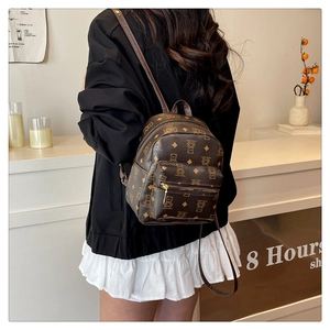 Detail eines braunen Mini-Rucksacks mit Bärenmuster am Rücken des Models gezeigt