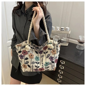 Detail of floral tapestry tote bag with thick rope handles and textured flower pattern