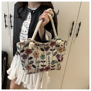 Detail of vintage floral tote bag featuring colorful patterns and thick cotton rope handles