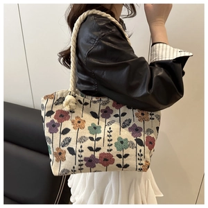 Floral canvas tote bag with thick rope handles shown on a model in a stylish setting