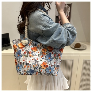 Detail of 3D floral tote bag with blue and orange flowers and white rope strap